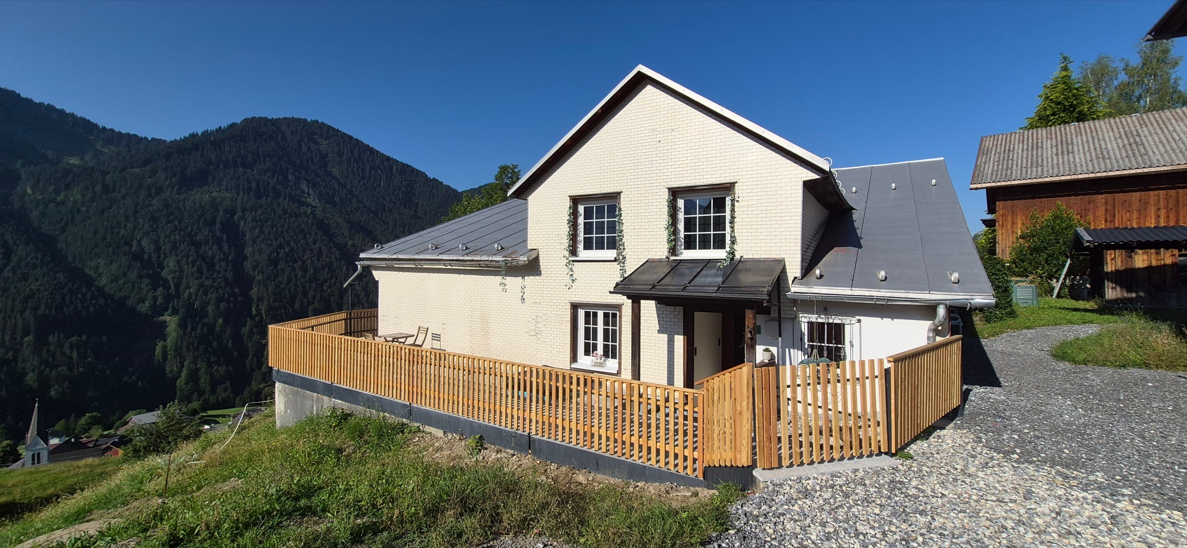 Bergnest holiday home in Innerlaterns with wooden fence, sun terrace and forested mountains behind