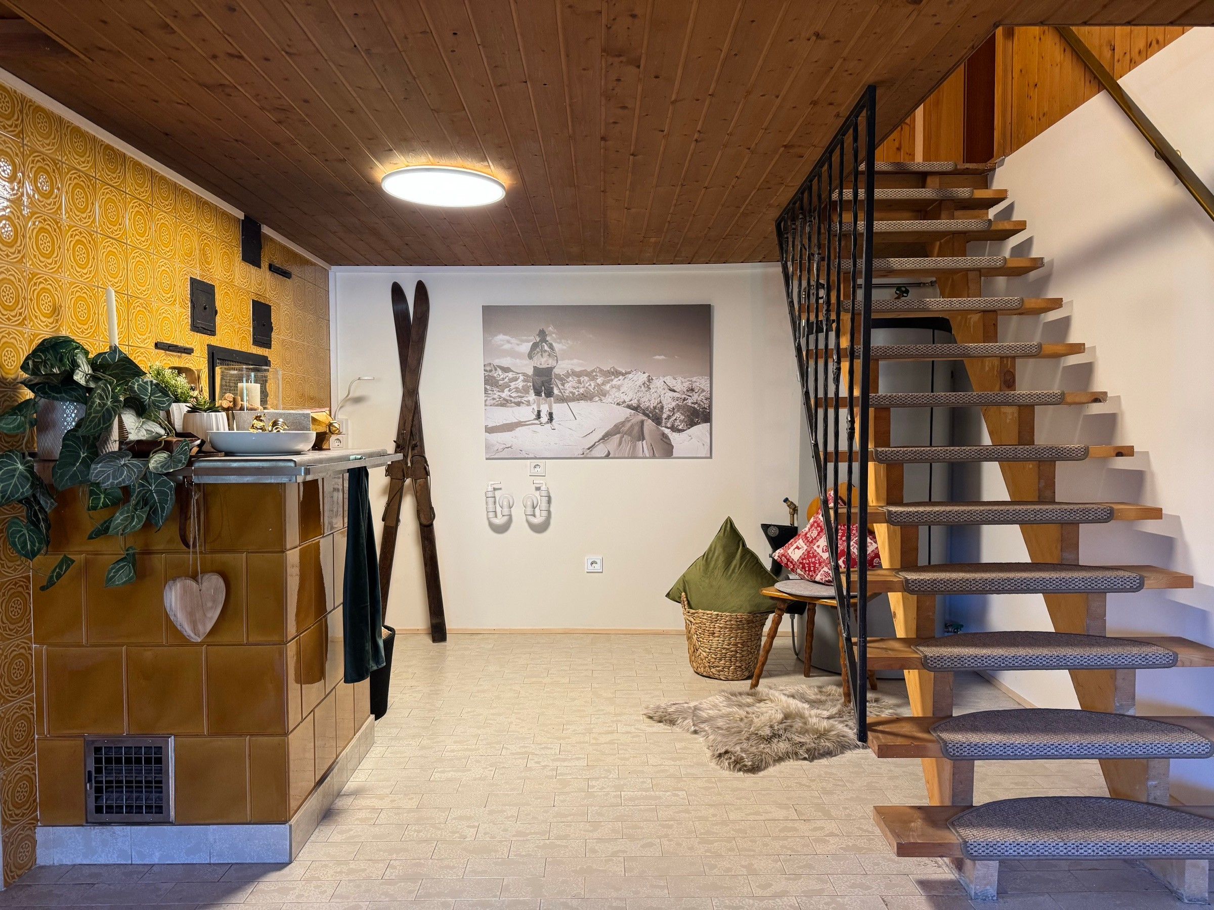 Hallway with vintage tiled wall, old wooden skis and wooden staircase