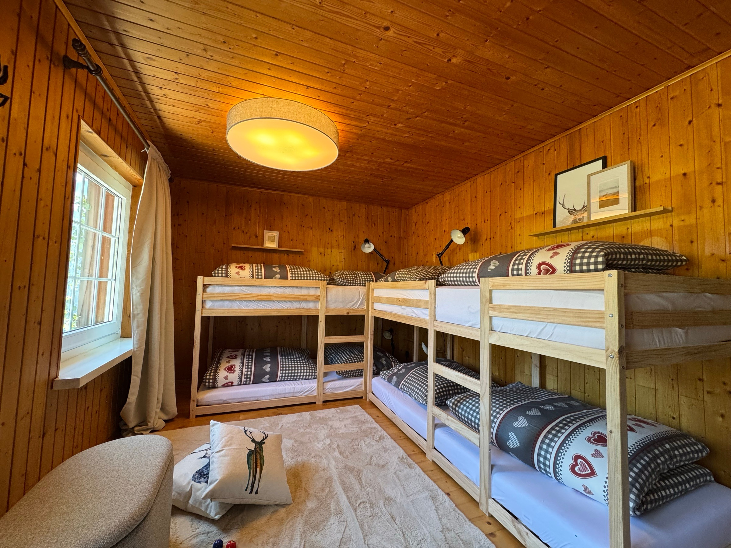 Kids’ room with two wooden bunk beds and heart-patterned bedding